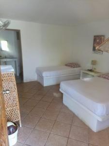 un soggiorno con 2 letti e un pavimento piastrellato di Habitaciones en Vichayito a Vichayito Altre 11 foto