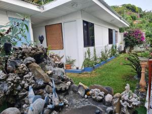 ein Garten mit einem Steinhaufen vor einem Haus in der Unterkunft mahinas lodge in Mahina