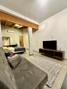 a living room with a couch and a flat screen tv at Refugio 890 in Tubarão