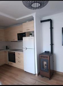 een keuken met een witte koelkast en een fornuis bij El apartamento de Isa in María
