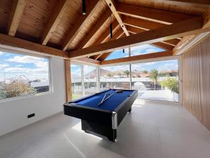 a pool table in a room with windows at Luxury Family Villa with Private Pool, Jacuzzi & Sauna in Tahiche