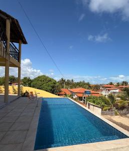 een zwembad met een stoel naast een huis bij Casa da Duna Moitas-Icaraizinho de Amontada Ceará in Praia de Moitas