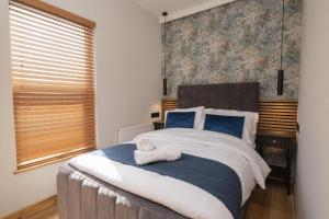 une chambre avec un grand lit avec des serviettes dessus dans l'établissement Double Room 18 Self Check-In Accommodation, à Hull