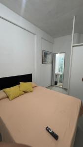 a bedroom with a bed with a remote control on it at Suíte Macedônia in Arraial do Cabo