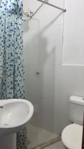 a bathroom with a sink and a toilet and a shower at Suíte Macedônia in Arraial do Cabo