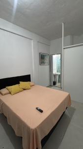a bedroom with a bed with a remote control on it at Suíte Macedônia in Arraial do Cabo