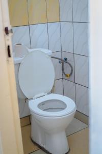 een badkamer met een wit toilet in een stal bij Villa Bernadette aéroport in Pointe-Noire +9 foto's