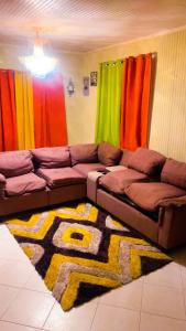 un soggiorno con divano e tende colorate. di Tamaras Inn a Christ Church