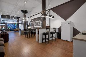 a room with a bar with chairs and a refrigerator at St. Vincent Lofts in Los Angeles