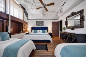 a bedroom with two beds and a ceiling fan at St. Vincent Lofts in Los Angeles