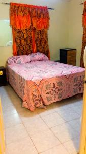 una camera da letto con letto e tenda arancione di Tamaras Inn a Christ Church