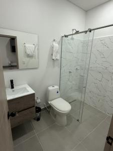 een badkamer met een douche, een toilet en een wastafel bij Tierra Bendecida Hotel Boutique in Villavicencio