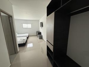 een kamer met een bed en een kamer met een deur bij Tierra Bendecida Hotel Boutique in Villavicencio