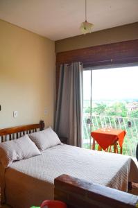 a bedroom with a bed and a large window at Casa clima da montanha 1 in Cunha