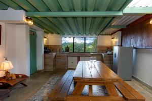 a room with a wooden table and a kitchen at Bhoga Forest  +54 photos
