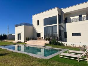 a house with a swimming pool in front of it at Luxury Villa Lam atlas view in Marrakesh