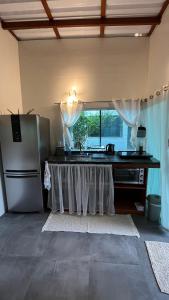 a kitchen with a table and a refrigerator at Tiny House Armação no Morro in Florianópolis