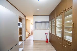 a kitchen with wooden cabinets and a red vacuum at FUJIMI Place in Yamanashi