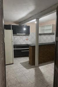 an empty kitchen with a counter and a refrigerator at Casa Caponga in Cascavel