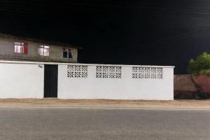 a white wall with a door on the side of a building at Casa Caponga in Cascavel