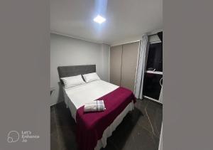 a bedroom with a bed with a purple blanket at Apto elegante no Catolé 33 in Campina Grande +31 photos