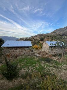 un vieux bâtiment en pierre avec un toit bleu dans un champ dans l'établissement Le Sommet Naturel, à Chefchaouen