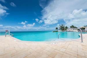 a swimming pool with the ocean in the background at 2 BDM, 2 Bath - Bimini Bay Resort in Bailey Town