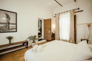 een slaapkamer met een wit bed en een groot raam bij Hotel Sin Nombre in Oaxaca City +87 foto's