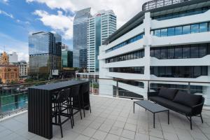 un balcon avec une table et des chaises sur un immeuble dans l'établissement Chic Princes Wharf Studio - City View - Parking, à Auckland