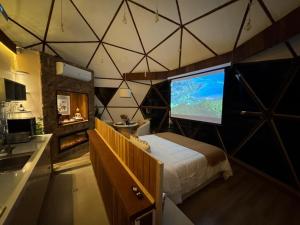 a bedroom with a large screen in a tent at Exclusive Cabanas BOLHA LUXO in Serra Negra