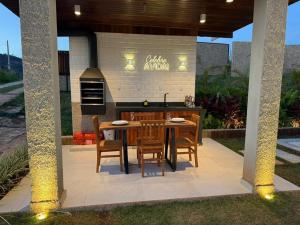 an outdoor kitchen with a table and chairs at Exclusive Cabanas BOLHA LUXO in Serra Negra