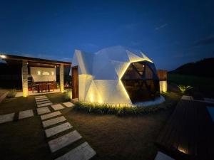 a modern house with a lit up facade at night at Exclusive Cabanas BOLHA LUXO in Serra Negra +4 photos