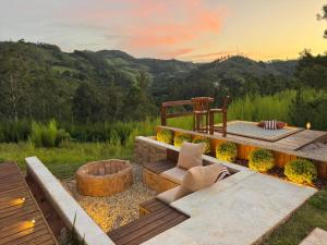 a backyard with a fire pit and a bench and chairs at Exclusive Cabanas BOLHA LUXO in Serra Negra