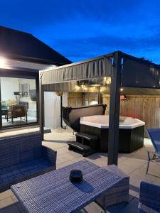 een terras met een jacuzzi en een badkuip bij Knockalla Lodge in Ballygowan