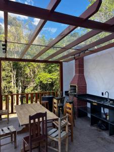 a patio with a table and chairs and a fireplace at Pousada do Rui in Caparaó Velho
