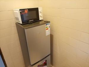 a microwave sitting on top of a refrigerator at Titi garage meublé in Yaoundé