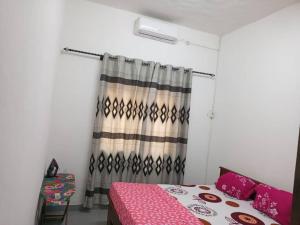 a bedroom with a bed and a shower curtain at Titi garage meublé in Yaoundé