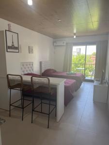 a bedroom with a bed and a table and chairs at Escobar Centro II in Belén de Escobar