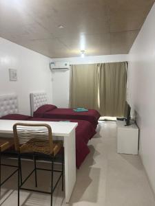 a bedroom with a bed and a table and a desk at Escobar Centro II in Belén de Escobar