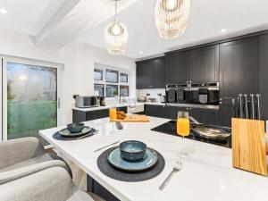 a kitchen with black cabinets and a white counter top at Spacious 3BR 3-Bath Modern Home Warrington in Warrington