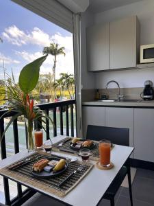 a table with two plates of food on a balcony at Studio Les Marines V - calme - vue sur le golf in Saint-François