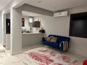 a living room with a blue couch and a kitchen at One Bedroom Apartment - Port Said Sea View Chalet in Port Said