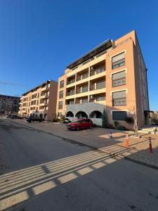 a large building with a red car parked in front of it at Royal Queen in Vrnjačka Banja