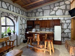een keuken met houten krukken en een witte koelkast bij Cabañas las Gemelas in Areponapuchi