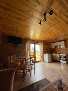 a kitchen and dining room with a wooden ceiling at Planinska kuća Petrović in Zaovine