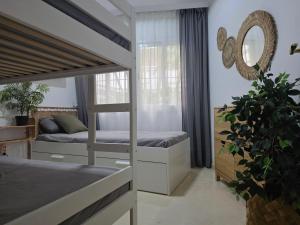 een slaapkamer met 2 stapelbedden en een spiegel bij Apartment Beachfront Accommodation in Estepona