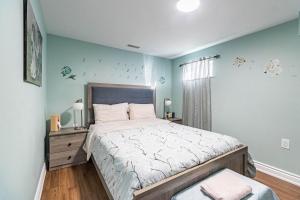 ein Schlafzimmer mit einem großen Bett mit blauen Wänden in der Unterkunft Entire Basement Apartment in Toronto