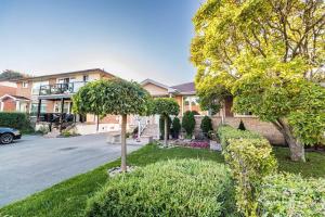 ein Haus mit Bäumen vor einer Straße in der Unterkunft Entire Basement Apartment in Toronto