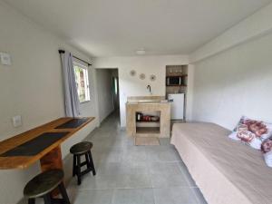 a living room with a bed and a kitchen at Pousada a 500 metros do Pico Malwee in Jaraguá do Sul