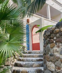 a stairway leading up to a red door at Sol - Casa MoJo's charming 1BR, kitchen, pool in Sayulita +2 photos